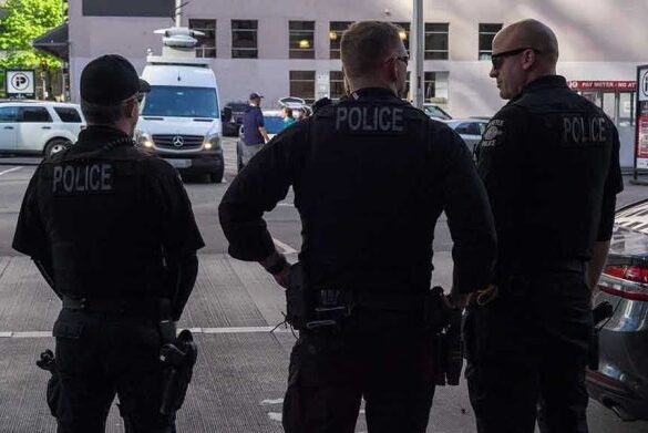 Three police officers standing on a city street.
