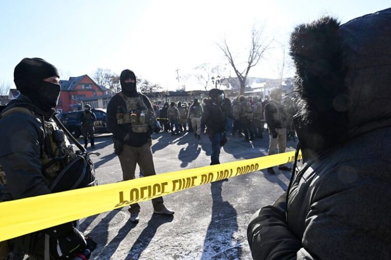 MINNEAPOLIS, MINNESOTA - JANUARY 24: Federal agents block off the scene of a shooting as crowds gather on January 24, 2026 in Minneapolis, Minnesota. Agents allegedly shot a protestor amid a scuffle to arrest him. The Trump administration has sent a reported 3,000 federal agents into the area, with more on the way, as they make a push to arrest undocumented immigrants in the region. (Photo by Stephen Maturen/Getty Images)