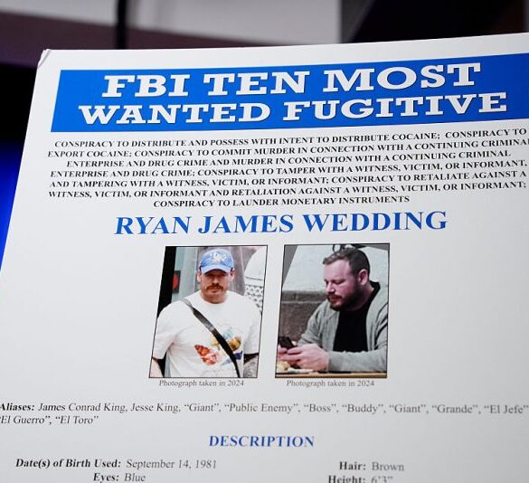 WASHINGTON, DC - NOVEMBER 19: A FBI Ten Most Wanted Fugitive poster is displayed during a news conference announcing the indictment of a former Olympic snowboarder Ryan Wedding, charging him with murder and money laundering in connection to a drug trafficking organization at the Justice Department on November 19, 2025 in Washington, DC. The Justice Department announced a fifteen-million-dollar reward for information leading to the arrest of Ryan James Wedding, the leader of a criminal drug organization who smuggled large quantities of cocaine through Colombia and Mexico for distribution in the United States and Canada. (Photo by Andrew Harnik/Getty Images)