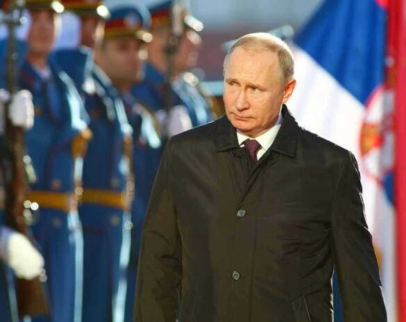 A man in dark coat at a military event.