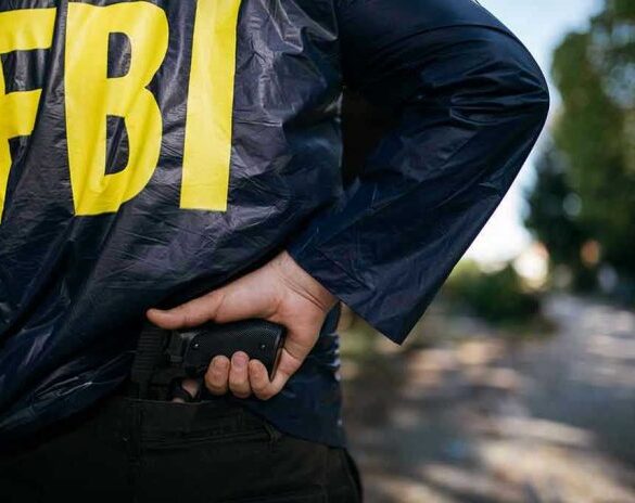 FBI agent holding a gun behind the back.