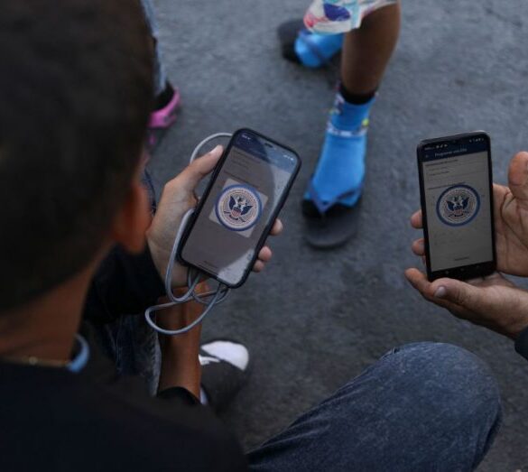 Venezuelan migrants browse the CBP One mobile app searching for an appointment to enter the United States outside the temporary stay of the National Migration Institute (INM) in Ciudad Juarez, Chihuahua state, Mexico, on May 5, 2023. Under the intense desert sun, among sand and brush, hundreds of migrants crossed the Rio Grande from Mexico on the rumor that the United States would let them in. But their hopes were dashed as they fell prey, once again, to misinformation. Falsehoods and deceptions add to the ordeal of these people, first to reach the border through Mexico and then to obtain asylum in the United States. (Photo by HERIKA MARTINEZ / AFP) (Photo by HERIKA MARTINEZ/AFP via Getty Images)