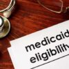 Stethoscope pen document about Medicaid eligibility on table