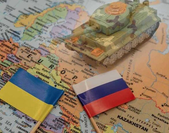 Toy tank on map with Ukraine and Russia flags.