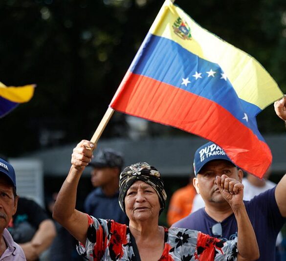 Supporters of Venezuela's President Nicolas Maduro flutter national flags in Caracas on January 3, 2026, after US forces captured Venezuelan leader Nicolas Maduro after launching a "large scale strike" on the South American country. President Donald Trump said Saturday that US forces had captured Maduro after bombing the capital Caracas and other cities in a dramatic climax to a months-long standoff between Trump and his Venezuelan arch-foe. (Photo by Pedro MATTEY / AFP via Getty Images)