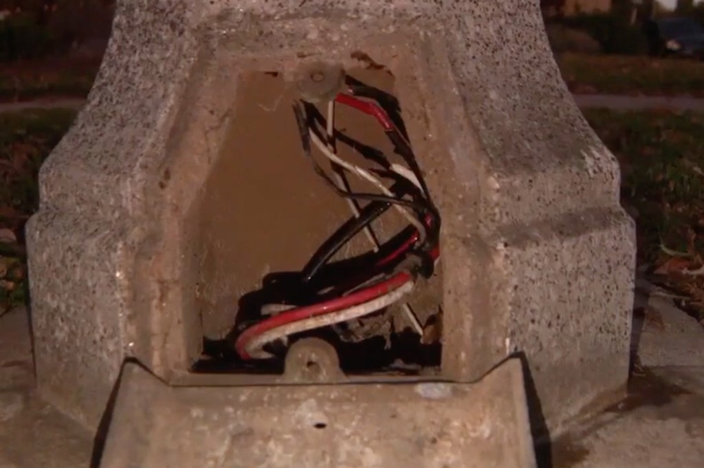 Exposed wires in a streetlight base after copper wire theft.