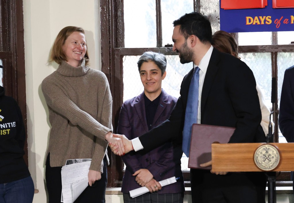 Zohran Mamdani and Cea Weaver shaking hands, with a woman in a purple jacket smiling between them.
