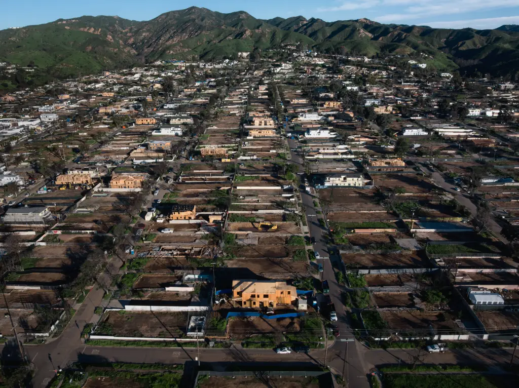 Aerial view of Pacific Palisades, California showing many homes under reconstruction in a fire-ravaged neighborhood.