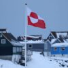 NUUK, GREENLAND - JANUARY 17: The Greenlandic flag flies over houses on January 17, 2026 in Nuuk, Greenland. Greenlandic, Danish and other European leaders are hoping they can still avert an intervention by the United States to forcefully acquire the island as U.S. President Donald Trump continues to insist the U.S. must have Greenland, suggesting even by military means if necessary. (Photo by Sean Gallup/Getty Images)