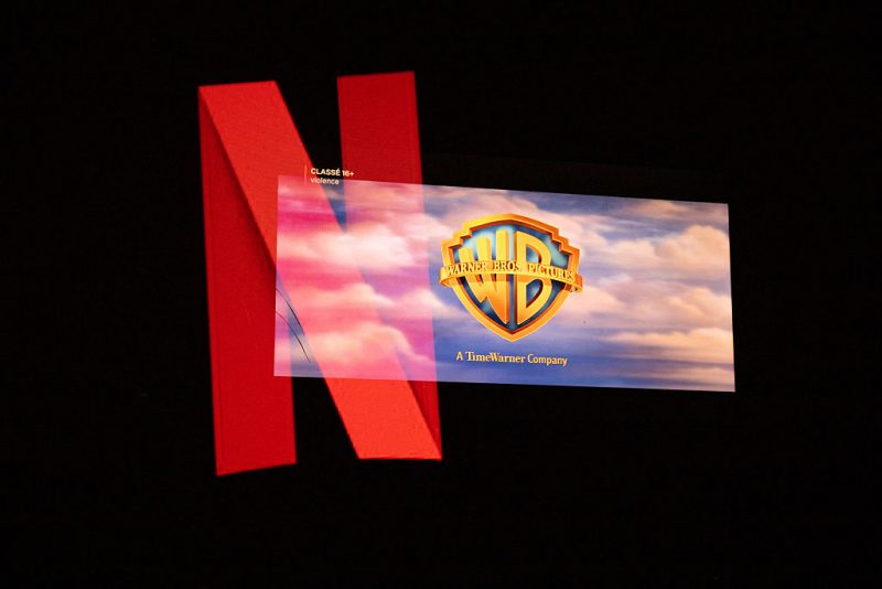 Double exposure photograph of the Netflix logo and the Warner Bros logo on a television screen at Kerlouan in Brittany in France on December 05 2025. (Photo by Vincent Feuray / Hans Lucas / AFP via Getty Images)