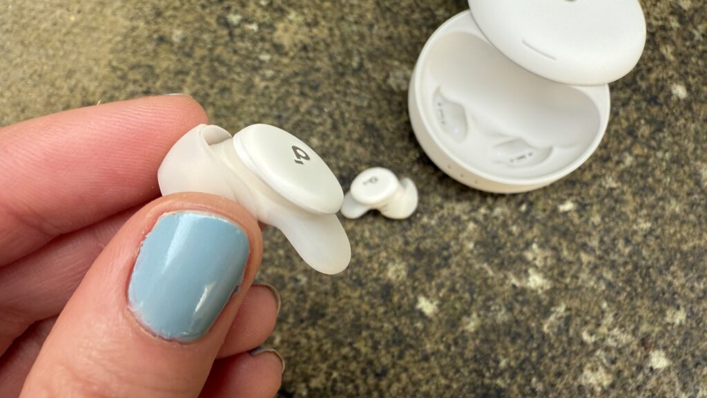 Someone holding one of the soundcore sleep a30 buds against a concrete surface