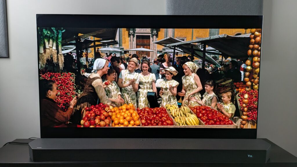 A shot of Maria and the Von Trapp children at a fruit stall at a market from The Sound of Music 4K Blu-ray on LG G5