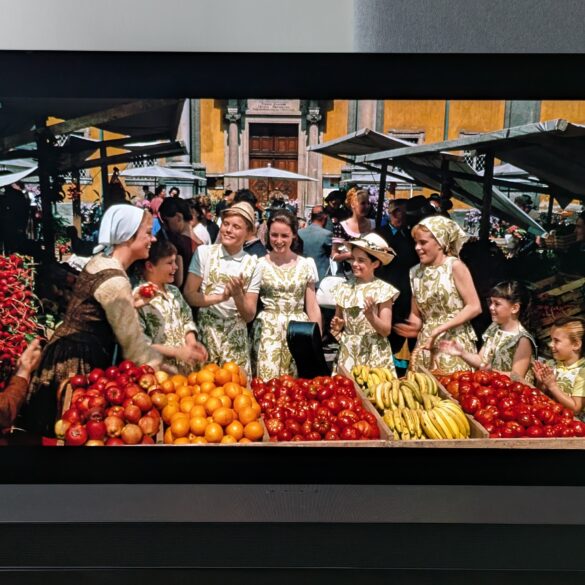 A shot of Maria and the Von Trapp children at a fruit stall at a market from The Sound of Music 4K Blu-ray on LG G5