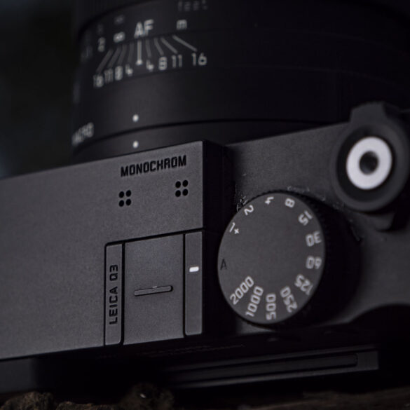 Leica Q3 Monochrom compact camera outside on a snow-dusted log