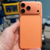 Apple iPhone 16 Pro Max in orange showing various Apple Messages features including sending check-ins, Apple Cash, and doodles