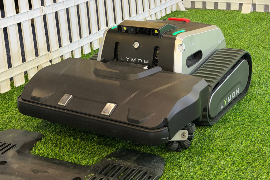 Lymow robotic lawnmower with tracks on artificial grass.