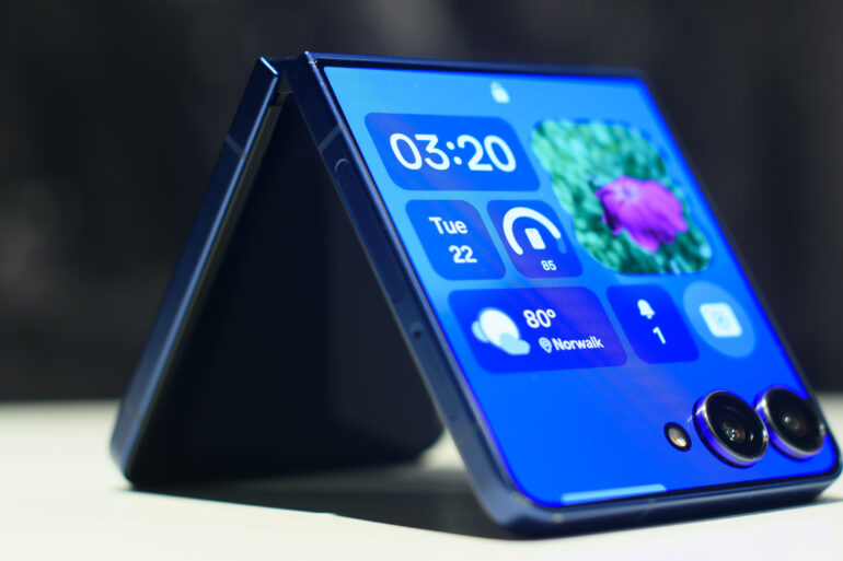 Samsung Galaxy Z Flip 7 in blue folded showing widgets on the cover display