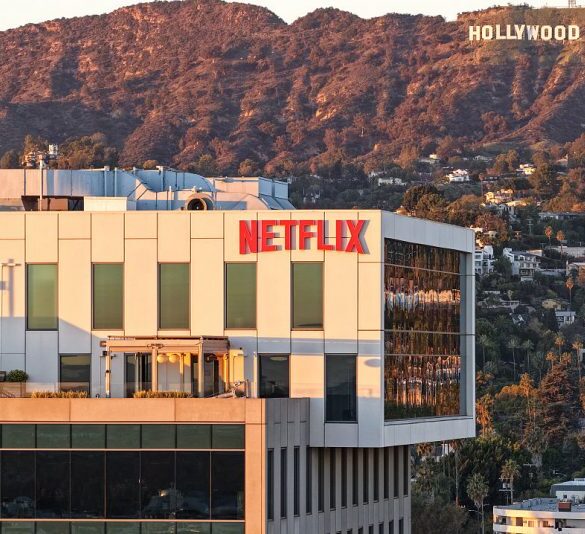 LOS ANGELES, CALIFORNIA - DECEMBER 05: An aerial view of the Netflix logo displayed at Netflix studios, with the Hollywood sign in the distance, on December 5, 2025 in Los Angeles, California. Netflix and Warner Bros. Discovery, Inc. have announced an $82.7 billion deal for Netflix to acquire Warner Bros. film and TV studios, HBO Max, and HBO. (Photo by Mario Tama/Getty Images)