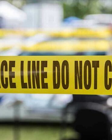 Yellow police line tape with Do Not Cross.