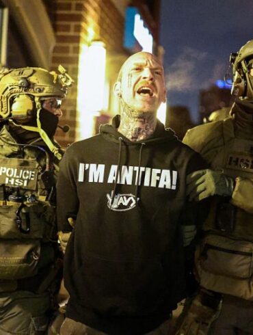 Federal agents with Homeland Security Investigations (HSI) detain a protestor wearing an "Antifa" shirt outside a residential building in Minneapolis, Minnesota, on February 5, 2026. US President Donald Trump suggested on February 4 that a "softer touch" may be needed on immigration, as his administration said 700 federal officers would be pulled from Minnesota but that mass deportations would not stop. The fatal shootings of two protesters by federal officers in Minneapolis last month sparked widespread outrage in the United States and calls for an end to immigration raids in the Midwestern city, but Trump's administration has been reluctant to shift course. (Photo by Charly TRIBALLEAU / AFP via Getty Images)