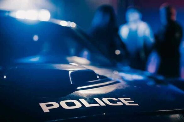 Police car with blurred figures in the background.