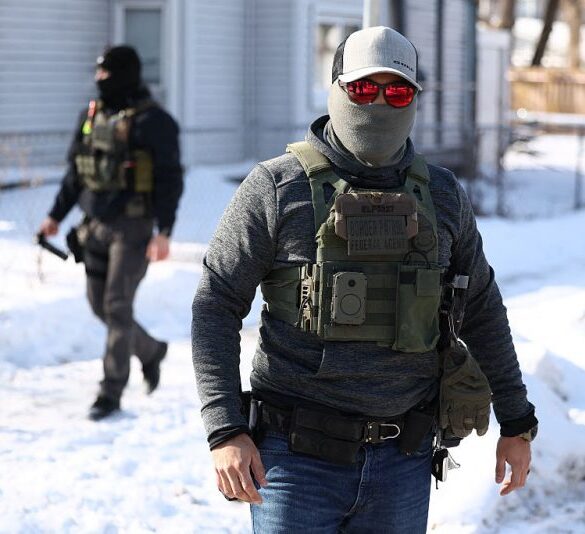 Federal agents look on after they detained a protester in Minneapolis, Minnesota on February 3, 2026. A US judge on January 31, 2026 denied Minnesota's bid to force Immigration and Customs Enforcement (ICE) to suspend its sweeping detention and deportation operation in the state that has left two US citizens dead and fueled massive protests. Masked and heavily armed federal agents have swept through Minnesota communities seeking undocumented migrants, detaining thousands and shooting dead two US citizens in the process. (Photo by Charly TRIBALLEAU / AFP via Getty Images)