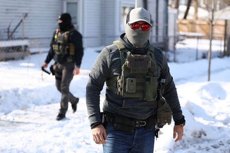Federal agents look on after they detained a protester in Minneapolis, Minnesota on February 3, 2026. A US judge on January 31, 2026 denied Minnesota's bid to force Immigration and Customs Enforcement (ICE) to suspend its sweeping detention and deportation operation in the state that has left two US citizens dead and fueled massive protests. Masked and heavily armed federal agents have swept through Minnesota communities seeking undocumented migrants, detaining thousands and shooting dead two US citizens in the process. (Photo by Charly TRIBALLEAU / AFP via Getty Images)