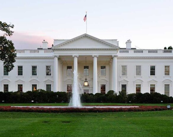 The White House with fountain and American flag.