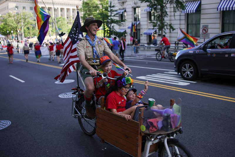 A person representing Scouting America rides a bicycle with children during the WorldPride 2025 parade in support of LGBTQ+ rights in Washington, D.C. on June 7, 2025. (Photo by Bryan Dozier / Middle East Images via AFP) (Photo by BRYAN DOZIER/Middle East Images/AFP via Getty Images)