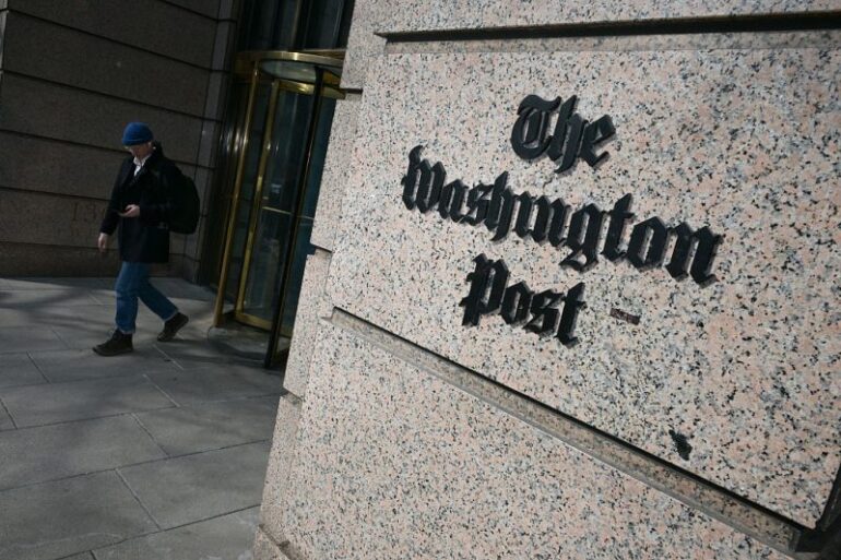 A man exits the Washington Post office building in Washington, DC, on February 4, 2026. The Washington Post, owned by billionaire Amazon founder Jeff Bezos, announced major job cuts on February 4, saying that "painful" restructuring was needed at the storied newspaper. The Post, which gained legendary status when it helped bring down president Richard Nixon in the Watergate scandal, will see "substantial" reductions in its newsroom, which until now had an estimated 800 journalists, Executive Editor Matt Murray said. (Photo by Oliver Contreras / AFP via Getty Images)