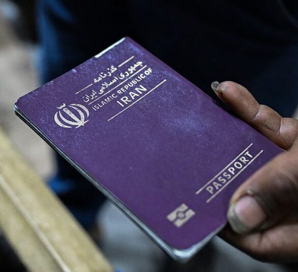 An Iranian street vendor shows her passport during an interview at the old market in Iraq's southern city of Basra on March 28, 2025. Every Friday, many Iranian peddlers endure the arduous journey into southern Iraq through the Chalamja border crossing, to sell essential goods such as chicken, eggs, cooking oil and household items in the markets of Basra, which serve as a haven for Iranians grappling with sharp currency depreciation and soaring inflation amid economic sanctions. (Photo by Hussein FALEH / AFP) (Photo by HUSSEIN FALEH/AFP via Getty Images)