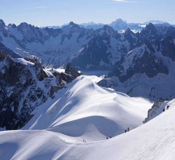 CHAMONIX-MONT-BLANC, FRANCE - JULY 02: Alpinists descend along a narrow ridge of ice and snow from the Aiguille Du Midi peak at 3,800 meters towards the Col du Midi basin in the Mont Blanc massif mountain range on July 02, 2024 near Chamonix-Mont-Blanc, France. The Col du Midi is part of the accumulation zone that contributes ice to the Mer de Glace, Europe's fourth biggest glacier and 12km long. The Mer de Glace, like nearly all of Europe's glaciers, is melting fast. According to glaciologists the Mer de Glace lost 800 meters in length between 1993 and 2018, as well as 120 meters in depth at its lower region. While Europe's glaciers have been steadily receding since the Little Ice Age that ended in the mid 19th-century, periods of intermittent glacier growth extended into the 1980s. Since then the glaciers have been receding rapidly, with the pace of melting accelerating sharply in the last decade. Scientists blame global warming, which is extending and intensifying the summer melting season of the glaciers. Diminished annual snowfalls are leaving the glaciers more exposed to the sun and preventing the formation of new ice. (Photo by Sean Gallup/Getty Images)