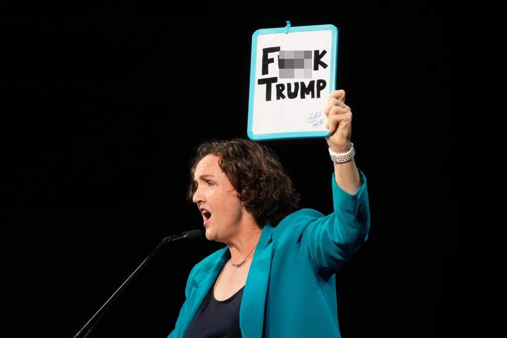 Katie Porter holding up a whiteboard that reads "F*** TRUMP."
