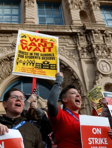 Teachers holding protest signs during a strike in front of Mission High School.