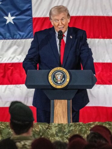 Donald Trump speaking at a podium with the Seal of the President of the United States, in front of an American flag.
