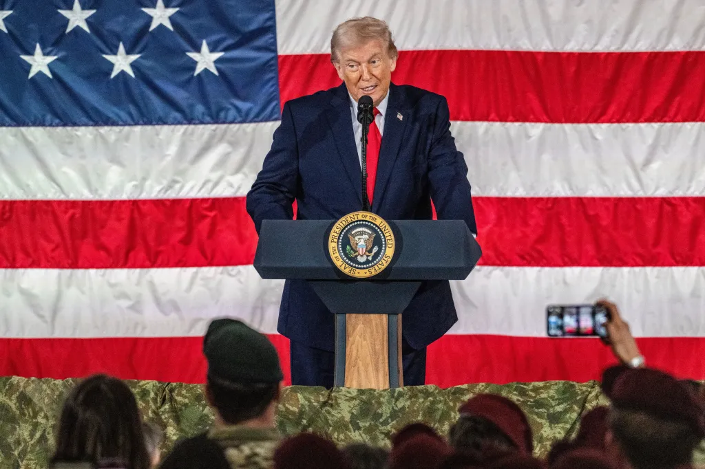 Donald Trump speaking at a podium with the Seal of the President of the United States, in front of an American flag.
