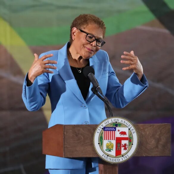 Los Angeles Mayor Karen Bass speaking at a podium with the city's seal.