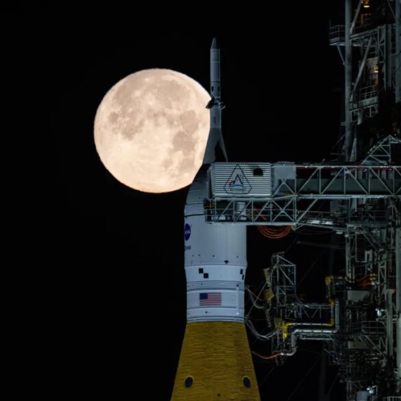Full moon rising behind the NASA SLS and Orion spacecraft.