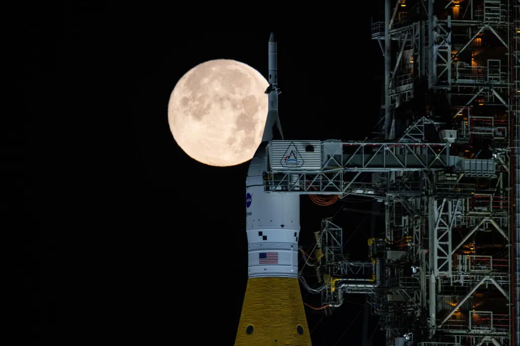 Full moon rising behind the NASA SLS and Orion spacecraft.