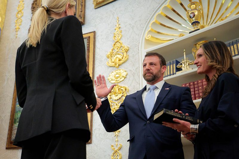 WASHINGTON, DC - MARCH 24: U.S. Attorney General Pam Bondi swears in former U.S. Sen. Markwayne Mullin (R-OK) as the next secretary of the Department of Homeland Security as his wife Christie Mullin holds a bible in the Oval Office at the White House on March 24, 2026 in Washington, DC. Mullin takes the helm of DHS during a challenging time as it has been partially shut down since February 14 while lawmakers negotiate reforms for Immigration and Customs Enforcement. (Photo by Chip Somodevilla/Getty Images)