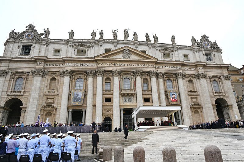 Pope Leo XIV delivers his speeck during the weekly general audience as portraits of late Italian teenager Carlo Acutis (R) and late Pier Giorgio Frassati (L) are displayed onto the facade of Saint Peter's Basilica in the background, in the Vatican on September 10, 2025. (Photo by Andreas SOLARO / AFP) (Photo by ANDREAS SOLARO/AFP via Getty Images)
