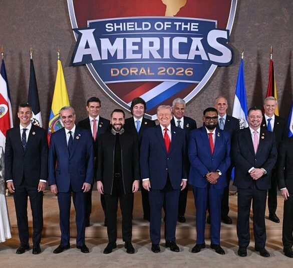 TOPSHOT - US President Donald Trump (C) stands with, (L/R), Trinidad and Tobago's Prime Minister Kamla Persad-Bissessar, Santiago Peña, President of the Republic of Paraguay, Luis Abinader, President of the Dominican Republic, Rodrigo Paz Pereira, President of Bolivia, Nayib Bukele, President of El Salvador, Javier Milei, President of Argentina, José Raúl Mulino, President of Panama, Mohamed Irfaan Ali, President of Guyana, Nasry "Tito" Asfura, President of Honduras, Rodrigo Chaves Robles, President of Costa Rica, José Antonio Kast, President-elect of Chile, and Daniel Roy Gilchrist Noboa Azín, President of Ecuador, during a group photograph at the start of the "Shield of the Americas" Summit at Trump National Doral in Miami, Florida, March 7, 2026. President Trump is hosting a dozen right-wing leaders from Latin America and the Caribbean to discuss issues facing the region, from organized crime to illegal immigration. The summit also aims to serve Washington by boosting US interests in the region and curbing those from foreign powers like China. (Photo by SAUL LOEB / AFP via Getty Images)