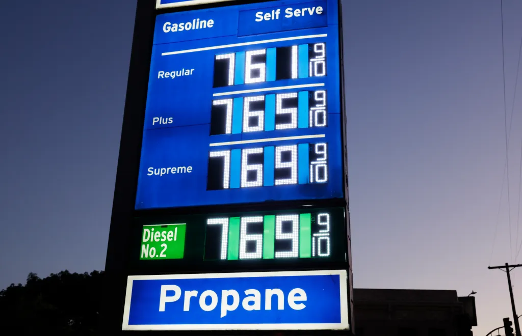 Gas prices displayed on a sign for Regular, Plus, Supreme, and Diesel No. 2 all showing $7.69 and 9/10, with a separate sign for Propane below.