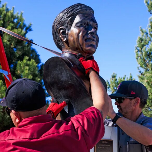 Workers removing a bust of Cesar Chavez from a park.