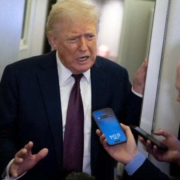 Donald Trump speaks to reporters, one of whom records him on a smartphone.