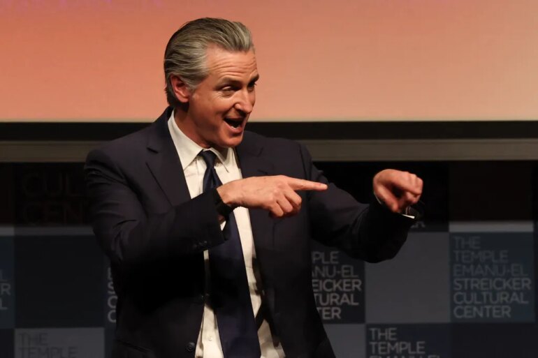California Governor Gavin Newsom speaking and gesturing with both hands.