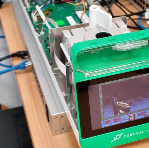 A microchip from Cortical Labs playing the video game Doom, displayed on a small screen.
