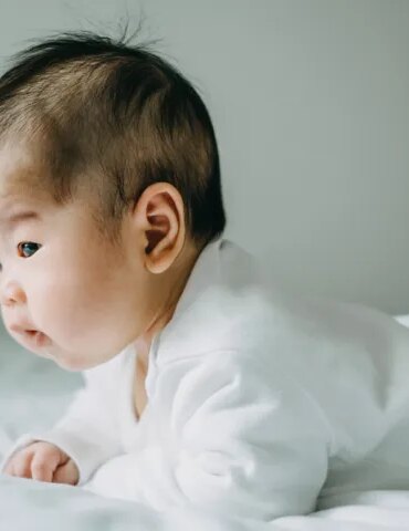 This baby perfectly demonstrates tummy time, an activity that helps build strength and mobility.