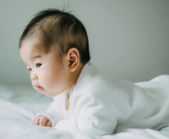 This baby perfectly demonstrates tummy time, an activity that helps build strength and mobility.